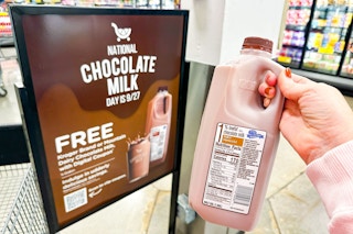 hand holding a half gallon of kroger chocolate milk with signage