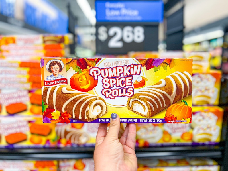 someone holding up a box of Little Debbie pumpkin spice rolls in Walmart