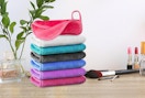 a stack of makeup remover clothes on a wooden table next to makeup