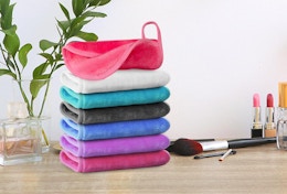 a stack of makeup remover clothes on a wooden table next to makeup