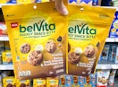 hand holding two belvita energy snack bites in walmart aisle