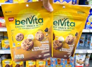 hand holding two belvita energy snack bites in walmart aisle