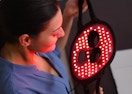 a person holding a light therapy mask