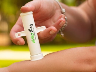 A person using a Bug Bite Thing suction tool on a child's arm.