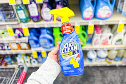 person holding a bottle of oxiclean laundry stain remover