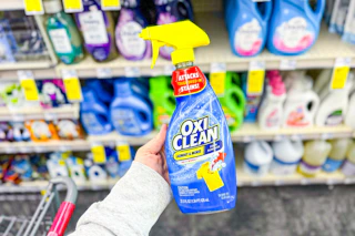 person holding a bottle of oxiclean laundry stain remover