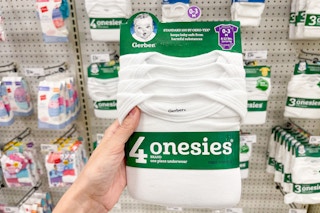 hand holding gerber onesies in front of a target shelf