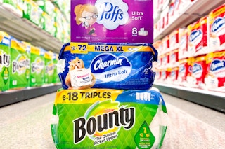 puffs, bounty, and charmin sitting on the floor in a target aisle