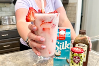 a person holding out a diy starbucks pink drink at home
