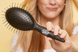 a woman holding a wet brush
