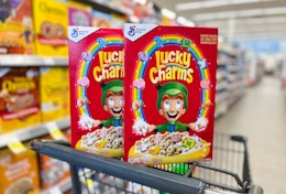 two boxes of lucky charms cereal balancing on shopping cart in store aisle