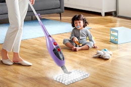 woman using steam mop on hardwood floors