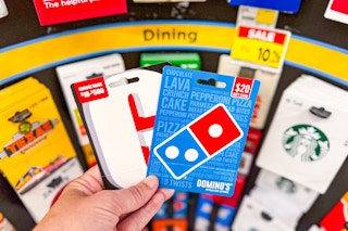 hand holding game stop and domino's gift card