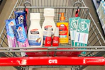 crest and toms toothpaste, palmers lotion, chi iron guard spray, and tree hut hand soap in a cart