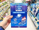 hand holding box of Clear Care Triple Action Cleaning Contact solution in aisle