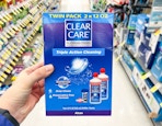 hand holding clear care contact solution twin pack