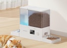 a dual pet feeder with water and food next to a cat