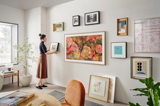 woman hanging art around samsung tv