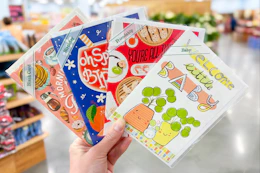 hand holding trader joes greeting cards