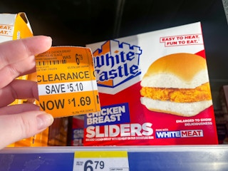 person holding a $1.69 clearance sign in front of white castle sliders