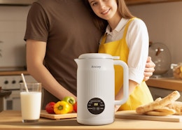 a coupe in a kitchen with a nut milk machine next to food on a counter
