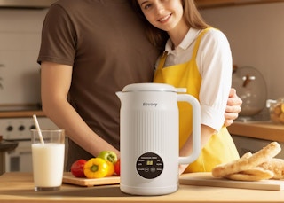 a coupe in a kitchen with a nut milk machine next to food on a counter