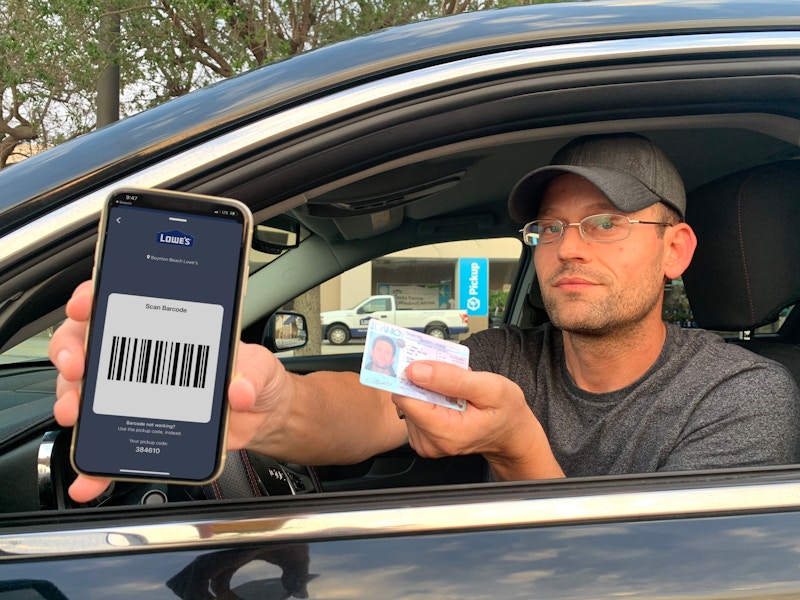 man holding photo id and cellphone with lowes scan barcode