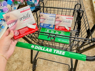 a person holding up white strips in a dollar tree