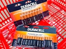 two packs of duracell batteries in a red shopping basket