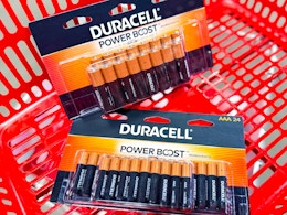 two packs of duracell batteries in a red shopping basket