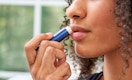 a person using a stick of lip balm 