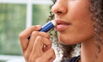 a person using a stick of lip balm 