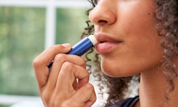 a person using a stick of lip balm