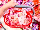 hand holding a target basket of valentine's day candy/snacks