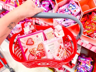 hand holding a target basket of valentine's day candy/snacks