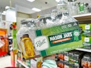 hand holding a ball half gallon mason jar set in front of target shelves