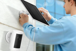 man installing solar panel on house