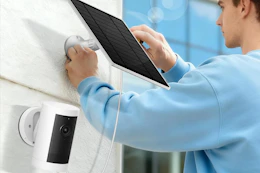 man installing solar panel on house