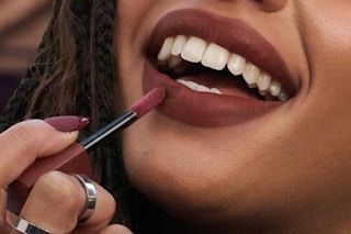 a woman applying a lip tint