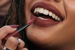 a woman applying a lip tint