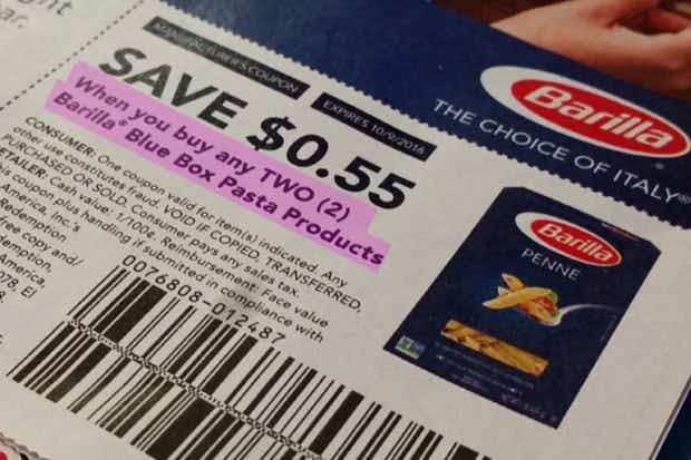 a close up on a manufacturer coupon for Barilla that says " Save 55 cents when you buy any TWO Barilla Blue Box Pasta Products" that is h...
