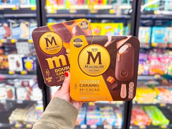 hand holding two magnum caramel ice cream bars in walmart frozen aisle