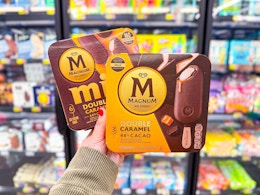 hand holding two magnum caramel ice cream bars in walmart frozen aisle
