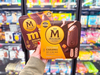 hand holding two magnum caramel ice cream bars in walmart frozen aisle