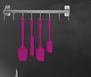 four pink spatulas on wall hooks