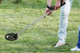 metal detector being used on grass
