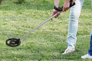 metal detector being used on grass