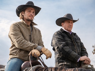Yellowstone cast members sitting on horses and looking off at something out of frame.