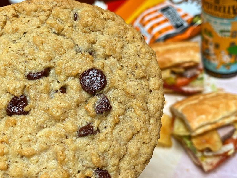 a person holding a cookie in front of their potbelly meal