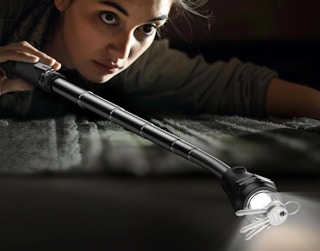 a person using a magnetic light tool to pickup keys